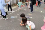 チョークを使って道路にお絵描きする子供たち = 2024年6月2日 十日町通り