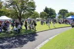 公園の広場に集まる出店者と訪れた学生や子連れなど = 市民公園 2024年10月13日