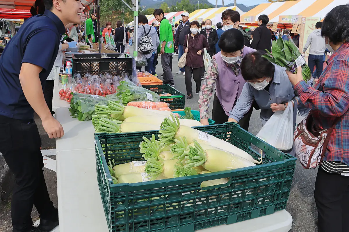 採れたての旬の上山産の野菜を買い求める人 = 2024年10月26日 三友エンジニア体育文化センター正面駐車場