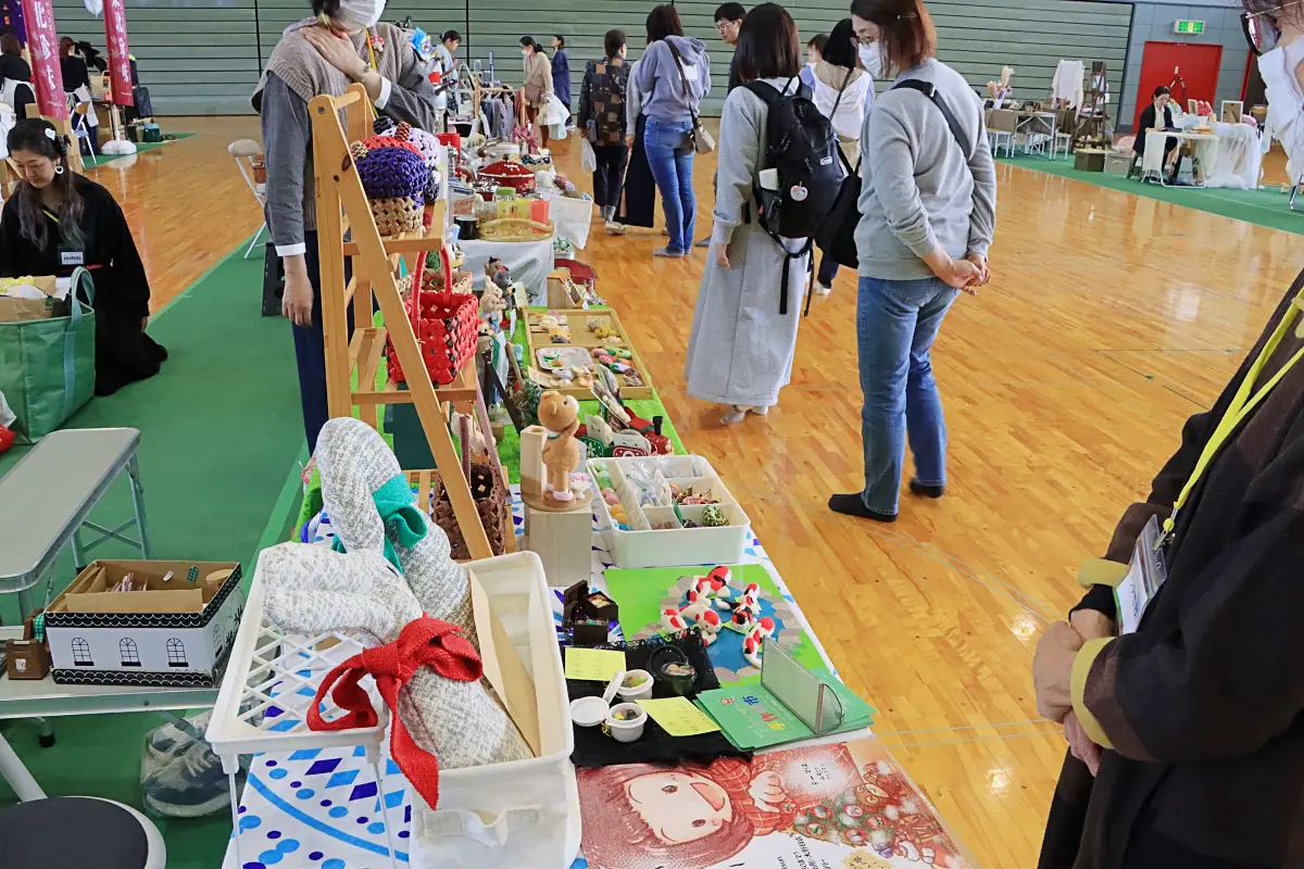 文化祭すこだまマルシェの会場で出品者の品を見て回る人 = 2024年10月27日 三友エンジニア体育文化センター